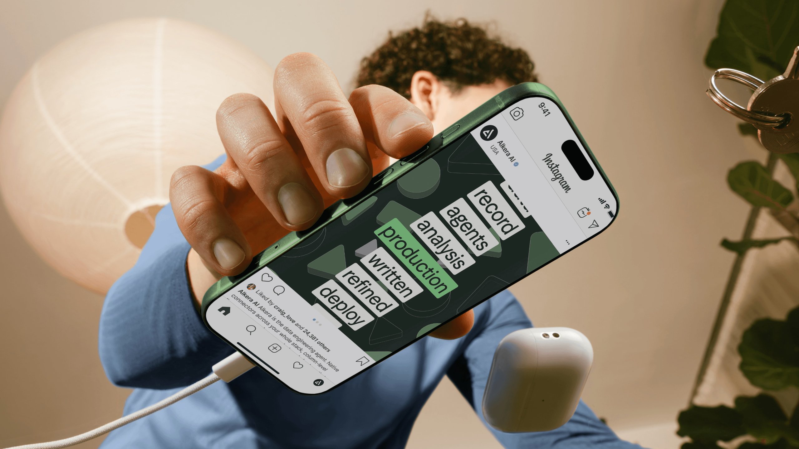 Hand holding a phone with Alkera social content